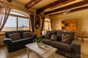 uma sala de estar com dois sofás e uma mesa em Orchidea Xaghra em Il-Pergla