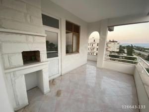 a living room with a fireplace and a balcony at Finike Apart in Finike