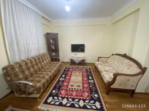 a living room with a couch and a tv at Finike Apart in Finike