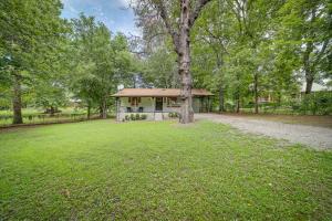 a house with a tree in the middle of a field at Wagoner Vacation Rental Near Fort Gibson Lake! in Wagoner