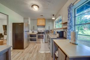 cocina con electrodomésticos de acero inoxidable y ventana grande en Wagoner Vacation Rental Near Fort Gibson Lake! en Wagoner