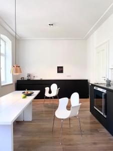 uma cozinha com cadeiras brancas e um balcão branco em Zehuus mit Domblick und Dachterrasse em Colônia