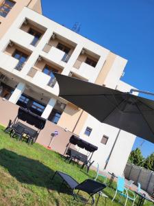 コスティネシュティにあるHotel DaMarのテーブル・椅子・傘付きの建物