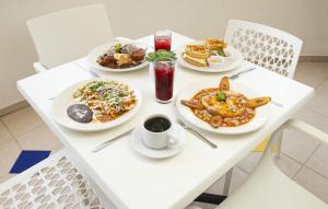 a white table with plates of food on it at Hotel Uxulkah in Campeche