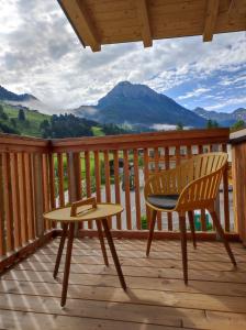 a wooden deck with a chair and a table at Appartements Amber in Kleinarl