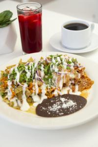 un plato de comida en una mesa con una bebida en Hotel Uxulkah en Campeche