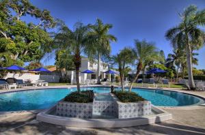 una piscina con palmeras y sombrillas azules en Gulfside Resort. Unit 10, en St Pete Beach
