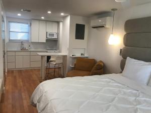 1 dormitorio con 1 cama blanca y cocina en Gulfside Resort. Unit 10, en St Pete Beach