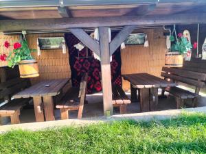 a group of wooden benches sitting under a pavilion at Vila Noris in Borşa