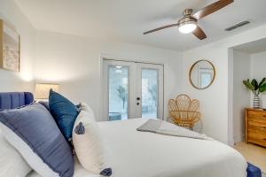 a bedroom with a white bed with blue pillows at Redington Beach Home Patio, Grill, Walk to Beach in St. Pete Beach