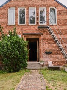 una casa de ladrillo con un banco delante de ella en Herrestad Bed & Guestroom, en Värnamo