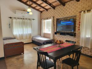 ein Wohnzimmer mit einem Tisch und einem TV in der Unterkunft CASAS Viñedos de Cafayate Alquiler Temporario in Cafayate