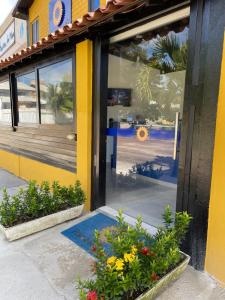 a door of a store with flowers in front of it at Pousada Girassol in Porto De Galinhas