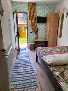 um quarto com uma cama e uma porta para um quintal em Vila Noris em Borşa