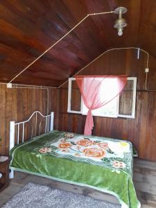 a bed in a wooden room with a window at Sítio pousada e Refúgio lazer e eventos in Santana do Livramento