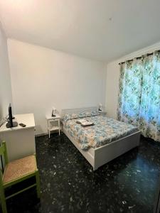 Schlafzimmer mit einem Bett, einem Schreibtisch und einem Fenster in der Unterkunft Casa Mirosa in Arenzano