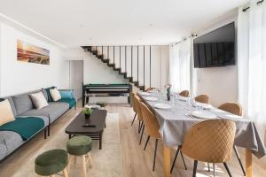 una sala de estar con una mesa larga y un sofá en Maison moderne avec jardin12 pers proche Paris & Disney en Neuilly-sur-Marne