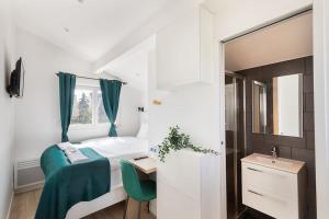 1 dormitorio con cama, escritorio y espejo en Maison moderne avec jardin12 pers proche Paris & Disney en Neuilly-sur-Marne