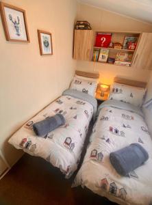 two beds in a small room at Gannets Rest - Spacious Static Caravan with Sea Views in Polperro