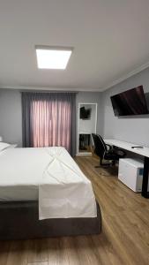 a bedroom with a large bed and a desk at Vila 90 Boutique Hotel in Tirana