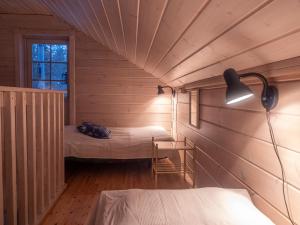 Zimmer im Dachgeschoss mit 2 Betten und einer Lampe in der Unterkunft Villa Vilttitossu in Äkäslompolo