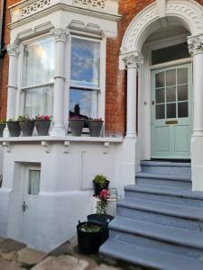 uma casa com vasos de plantas sobre um parapeito de janela em Three bedroom House em Londres