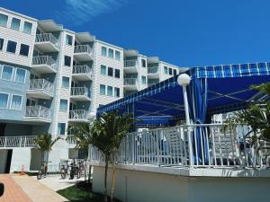 un gran edificio de apartamentos con un puente azul delante de él en El Coronado Resort, en Wildwood Crest