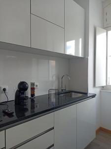a white kitchen with a sink and a counter top at FAMILY APARTAMENT II in Coimbra