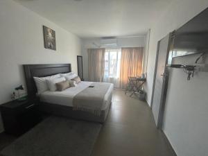 um quarto de hotel com uma cama e uma janela em Epic Springs Bed & Breakfast em Jwaneng