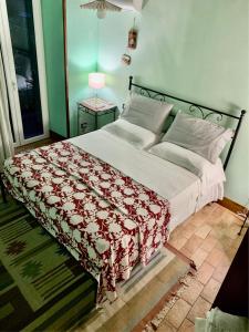 a bedroom with a large bed with a red and white blanket at Affittacamere Le Terrazze in Corniglia