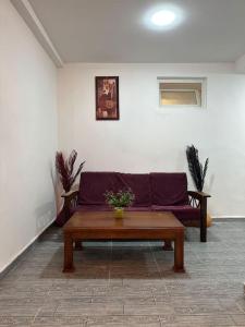 ein Wohnzimmer mit einem lila Sofa und einem Tisch in der Unterkunft Kahina loft in Bejaïa
