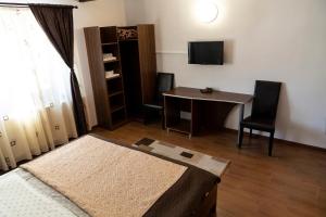 a room with a desk and a table and a television at Casa Parc in Predeal +24 photos