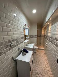 uma casa de banho com um lavatório e um WC num quarto em Kahina loft em Bejaïa