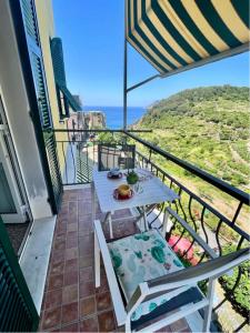einen Balkon mit einem Tisch, Stühlen und Meerblick in der Unterkunft Affittacamere Le Terrazze in Corniglia