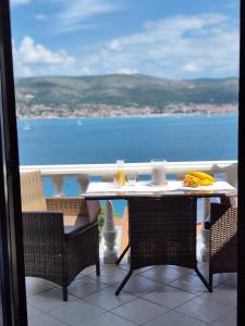 a table and chairs with a view of the ocean at Apartmani Roko in Okrug Donji