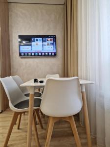 a room with a table and chairs and a tv on the wall at Expo Residence Astana in Astana