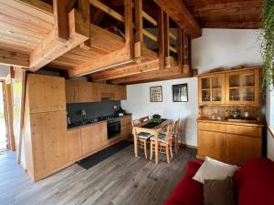 una cocina con armarios de madera y una mesa en una habitación en Il nido al Maso Maoro, en Sant’Orsola