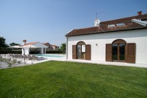 eine Villa mit Garten und Swimmingpool in der Unterkunft Villa Bosa in Poreč