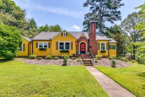 a yellow house with a red door at Charming Winston-Salem Studio on Miller Park! in Winston-Salem