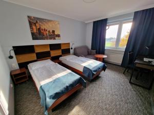 a hotel room with two beds and a desk at Hotel Podróżnik in Koszuty