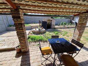 un patio con mesa, sillas y chimenea en Hannibal, en Bulhary