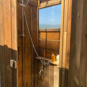 a shower in a wooden bathroom with a window at BorgoGuerzano77 in Camugnano
