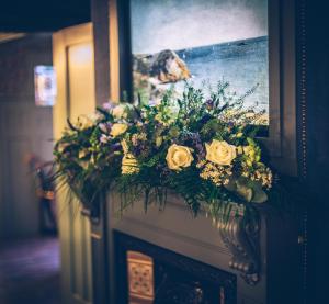 a bouquet of flowers sitting on top of a wall at Sheddington Manor - 2 Bedroom Guest House & Cinema in Belfast