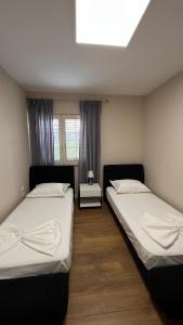 two beds in a room with a window at Vila 90 Boutique Hotel in Tirana +36 photos