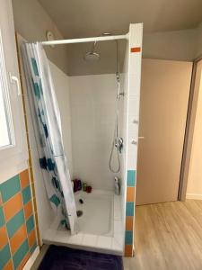 een badkamer met een douche en een douchegordijn bij La Villa Louca in Saint-Vincent-de-Tyrosse
