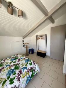 een slaapkamer met een bed met een bloemdekbed bij La Villa Louca in Saint-Vincent-de-Tyrosse