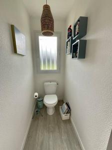 een kleine badkamer met een toilet en een raam bij La Villa Louca in Saint-Vincent-de-Tyrosse