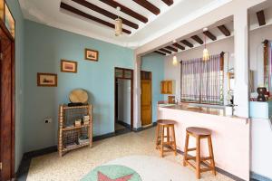 a kitchen with a counter and two stools in a room at KoMe House in Jambiani