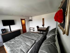 um quarto com uma cama e uma mesa com uma flor vermelha em Am Berg em Feldberg