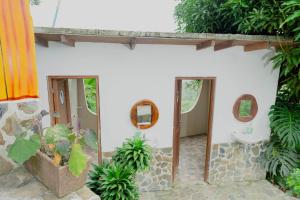 La salle de bains est pourvue de toilettes et de 2 miroirs. dans l'établissement Hostal Sierra Minca, à Minca